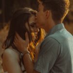 man kissing woman forehead