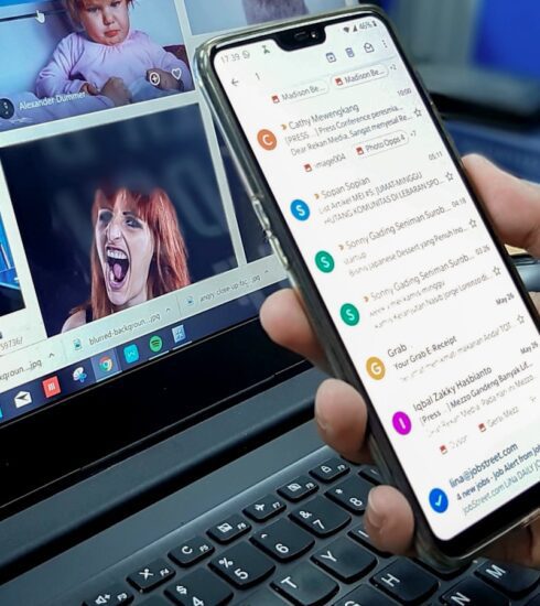 person using smartphone and laptop computer