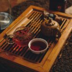 selective focus photography of cup of bowl beside brown teapot