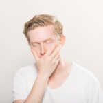 man covering his mouth