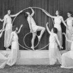 a group of women standing around a hula hoop